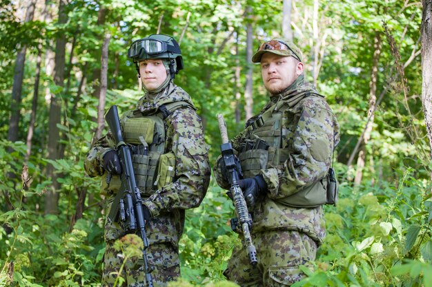 Les hommes militaires dans la forêt avec une mitrailleuse. Préparer les soldats au combat