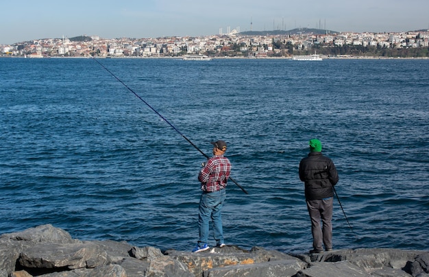 Hommes pêchant au bord de la mer