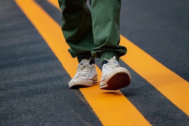 Hommes portant des baskets marchant dans les rues avec des lignes jaunes.