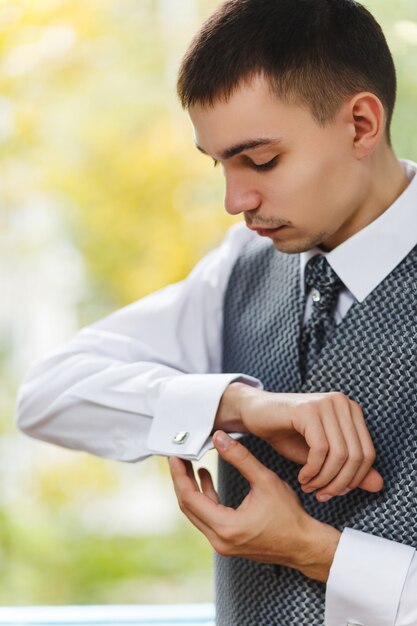 Photo les hommes portent des boutons de manchette