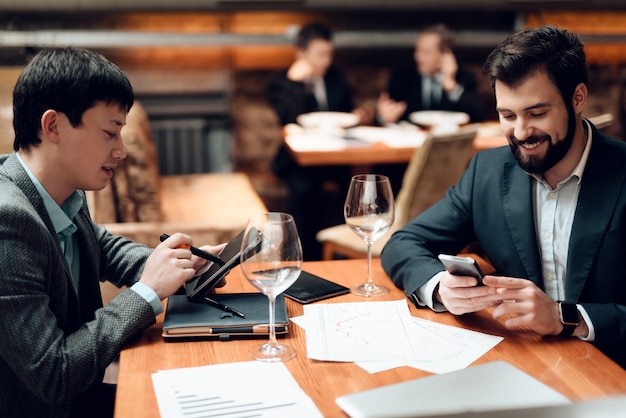 Les hommes regardent leurs téléphones.