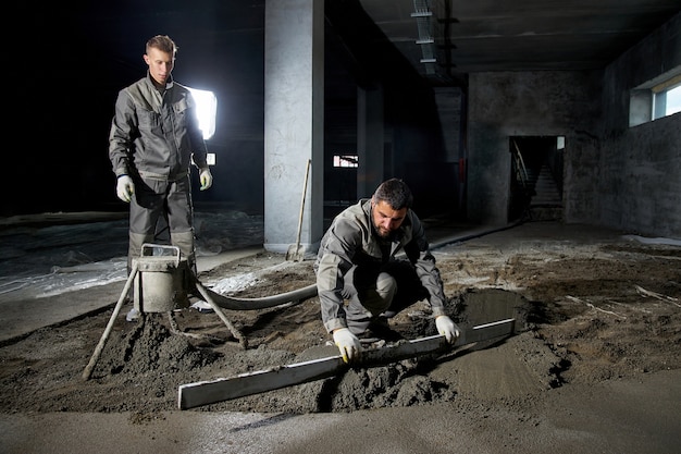 Photo les hommes remplissent le sol de béton