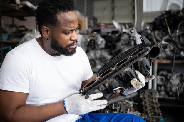 Hommes réparant le moteur d'une voiture dans un atelier de réparation automobile