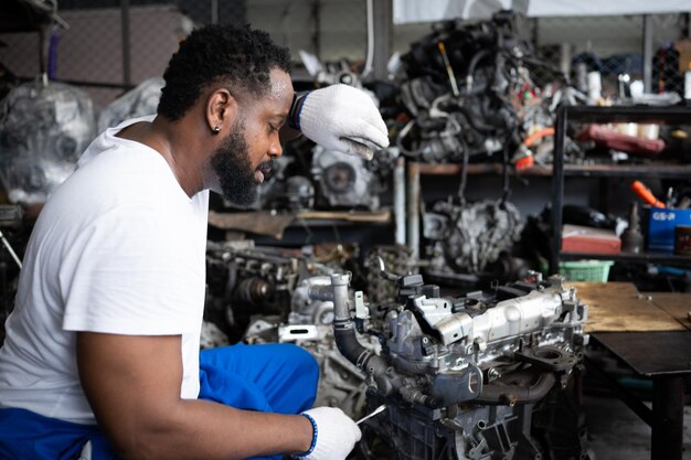 Hommes réparant le moteur d'une voiture dans un atelier de réparation automobile