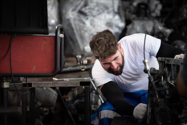 Hommes réparant le moteur d'une voiture dans un atelier de réparation automobile