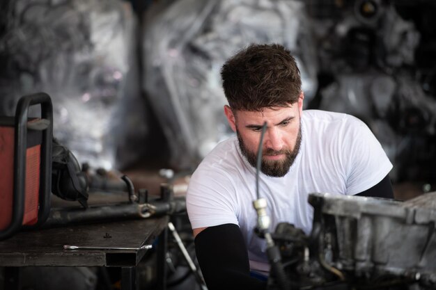 Photo hommes réparant le moteur d'une voiture dans un atelier de réparation automobile