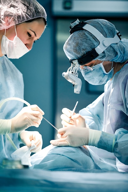 Hommes de rhinoplastie, les mains gantées du chirurgien tiennent les instruments pendant la chirurgie du nez. Le docteur en gants tient un instrument médical pendant la rhinoplastie.