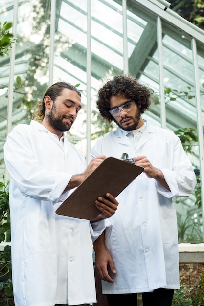 Hommes scientifiques discutant sur presse-papiers