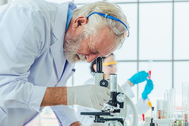 Des hommes scientifiques travaillant avec des produits chimiques microscopes en laboratoire