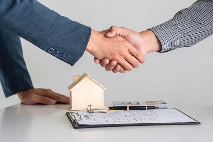 les hommes se serrent la main avec une petite maison en arrière-plan