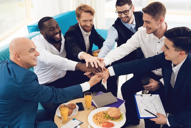 Les hommes sont habillés en costumes. Ils montrent le travail d'équipe.