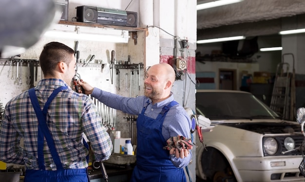 Hommes souriants en combinaison travaillant