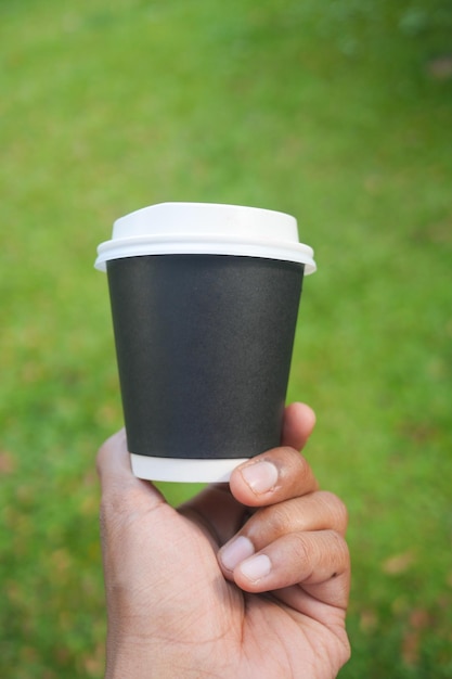 Hommes tenant une tasse de café en papier à emporter en plein air