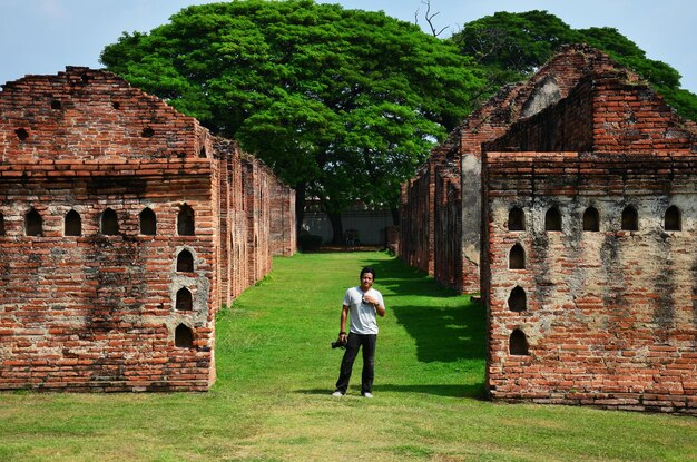 Les hommes thaïlandais photographes voyageurs voyagent visitent et utilisent un appareil photo numérique pour filmer des ruines antiques des bâtiments architecture antique du palais du roi Narai Ratchaniwet dans la ville de Lopburi à Lop Buri en Thaïlande