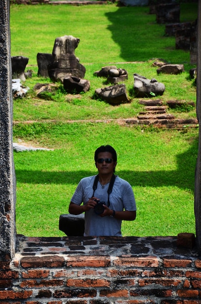 Des hommes thaïlandais photographes voyageurs voyagent visiter et utiliser un appareil photo numérique pour prendre des photos de ruines antiques bâtiments architecture antique de Wat Phra Sri Rattana Mahathat dans la ville de Lopburi à Lop Buri en Thaïlande