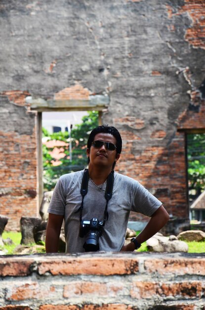 Des hommes thaïlandais photographes voyageurs voyagent visiter et utiliser un appareil photo numérique pour prendre des photos de ruines antiques bâtiments architecture antique de Wat Phra Sri Rattana Mahathat dans la ville de Lopburi à Lop Buri en Thaïlande