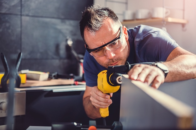 Hommes utilisant une perceuse électrique