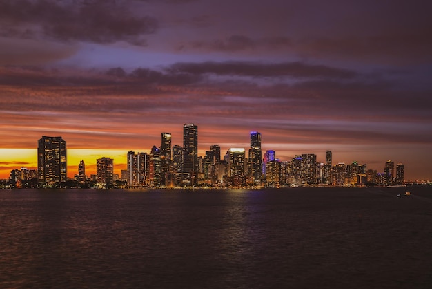 Horizon de paysage urbain de Miami la Floride sur le panorama de baie de Biscayne au crépuscule avec les gratte-ciel urbains et le pont au-dessus de la mer avec la réflexion