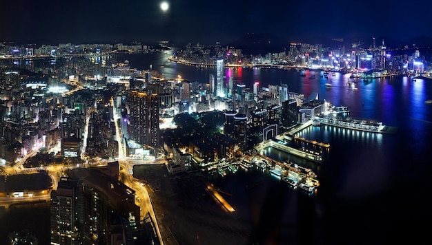 Photo un horizon de la ville avec une pleine lune et une ville la nuit