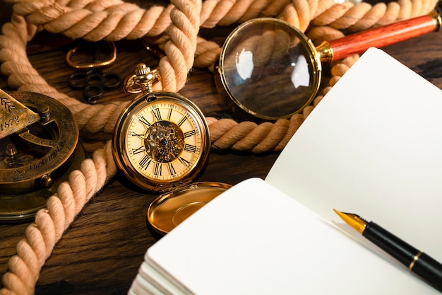 Horloge antique sur le fond du carnet et du stylo vintage. Feuille vierge pour écrire du texte.