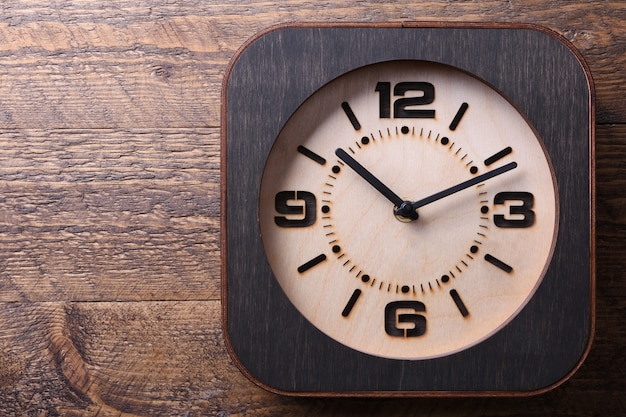 Horloge en bois faite à la main sur une table en bois. Fermer.