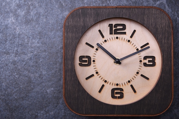 Horloge en bois faite à la main sur une table en bois. Fermer.