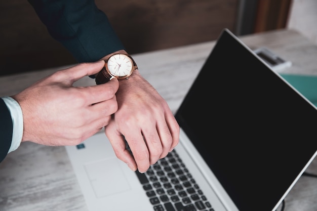 Horloge de main de l'homme sur fond de clavier d'ordinateur