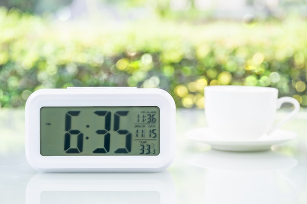 Horloge numérique au bureau avec une tasse de café