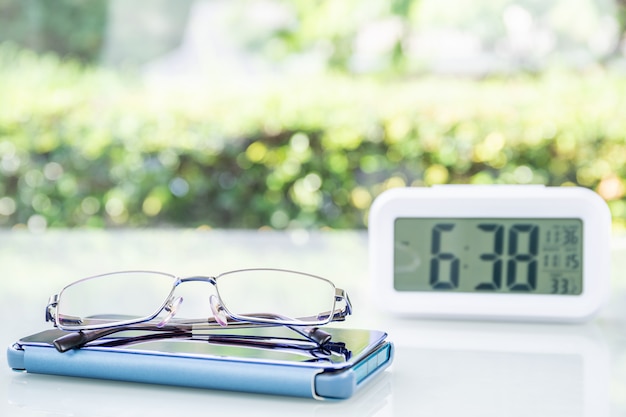 Horloge numérique et lunettes avec tasse à café