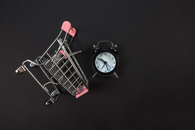 Horloge avec panier sur noir Shopping time