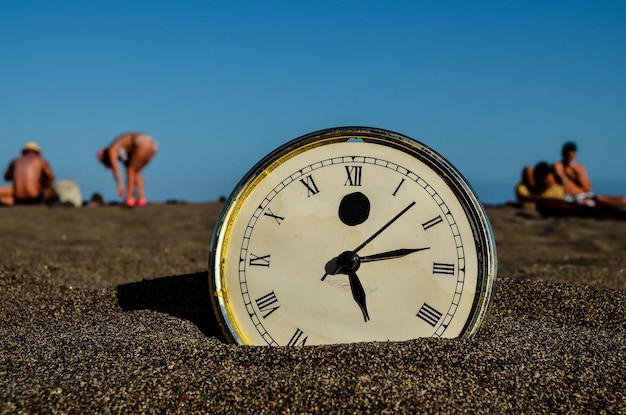 Photo l'horloge sur la plage de sable