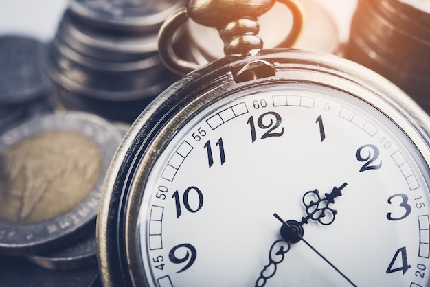 Photo horloge et rangées de pièces de monnaie pour le temps de la finance et le concept d'entreprise