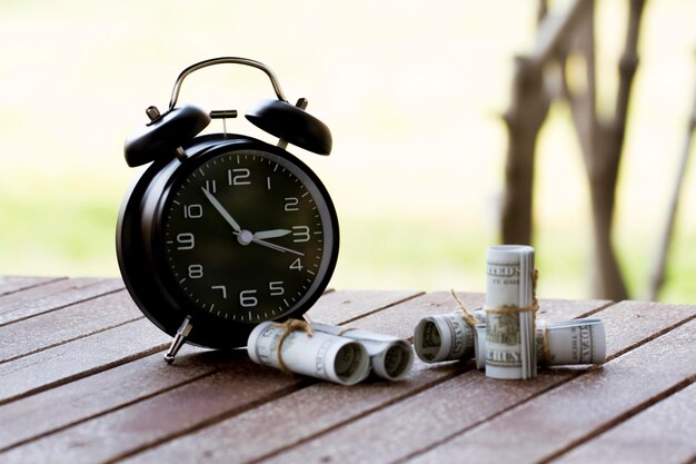 Photo horloge de réveil par monnaie de papier sur la table