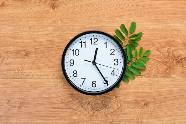 Horloge ronde sur une table marron. Vue de dessus. Espace libre pour votre texte. Mise à plat.