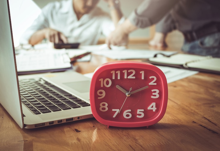 Photo horloge rouge pour temps d&#39;affaires sur le bureau en bois.