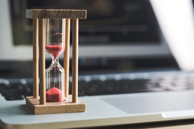 horloge de sable sur ordinateur portable .symbole de temps