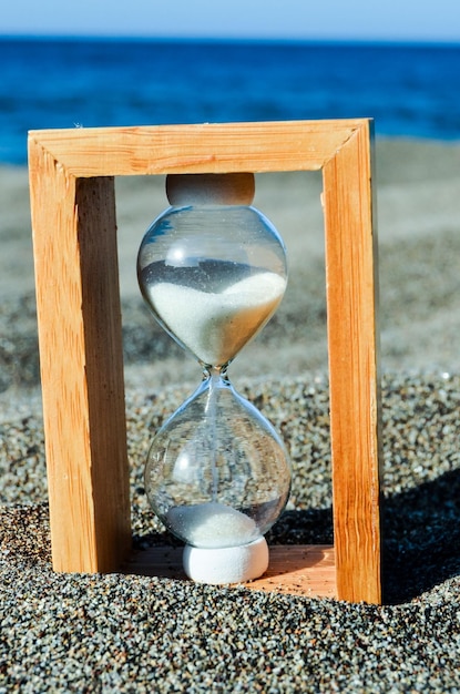 Photo l'horloge à sable sur la plage de sable