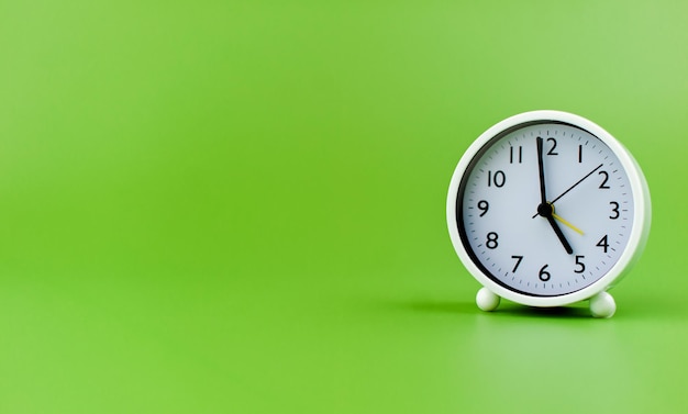 Horloge temps précieux réveil sur fond vert concept de temps de travail avec le temps