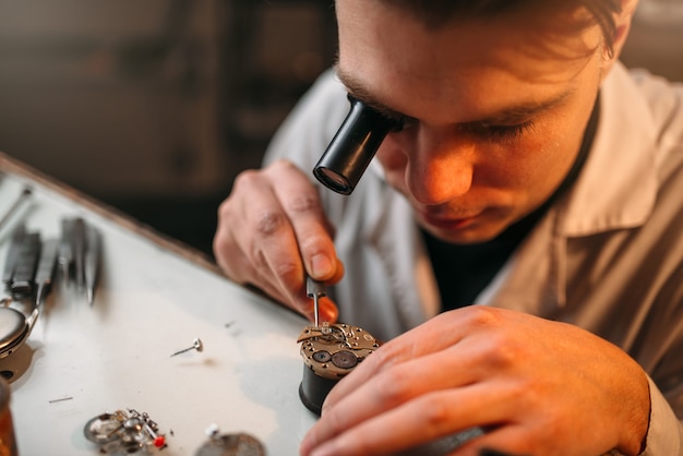 Photo horloger avec mécanisme d'horlogerie de réparation de loupe