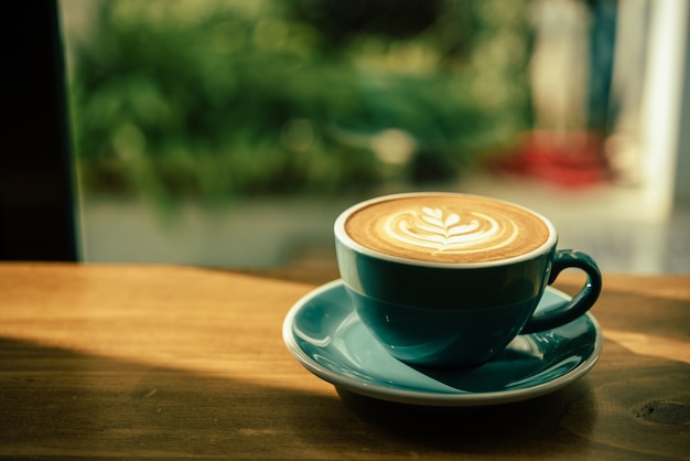 Hot art Latte Café dans une tasse sur la table en bois et la lumière du matin