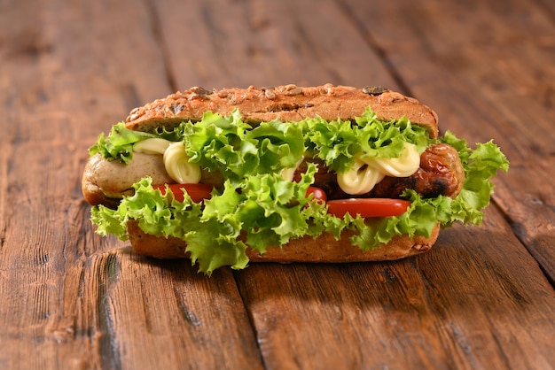 Hot-dog avec beaucoup de salade verte et vue de dessus de saucisses frites