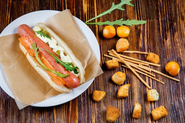 Hot Dog Avec Des Cornichons Et De La Roquette Et Des Collations à La Bière Fumée