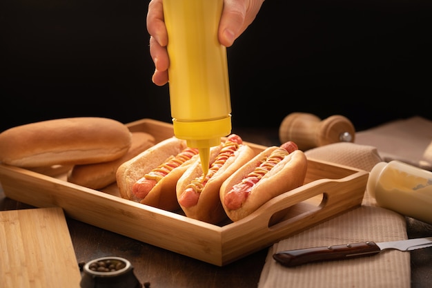 Hot-dog grillé au barbecue sur bois, style sombre.