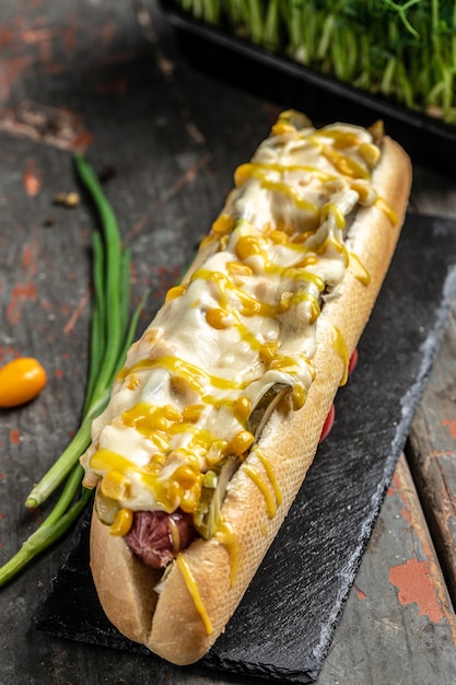Hot-dog grillé fait maison avec des saucisses enveloppées de fromage et de maïs, gros aliments malsains