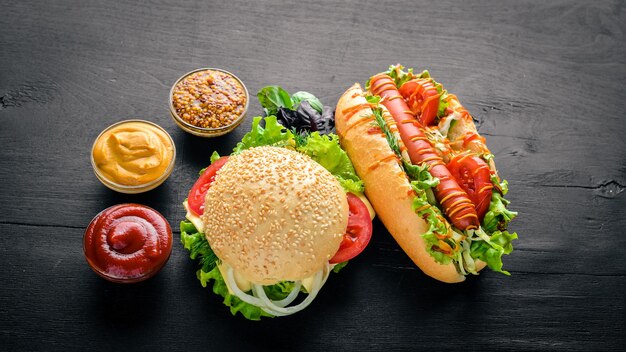 Hot-dog et hamburger avec viande au fromage et légumes verts sur fond en bois Vue de dessus Espace libre