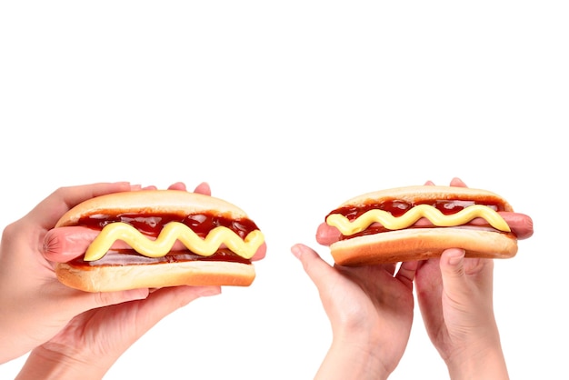 Hot-dog en main de femme isolé sur fond blanc. Espace de copie.