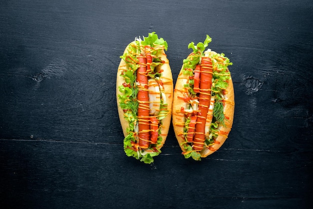 Hot-dog avec moutarde à la saucisse grillée et ketchup oignons et verts sur fond en bois Vue de dessus Espace libre