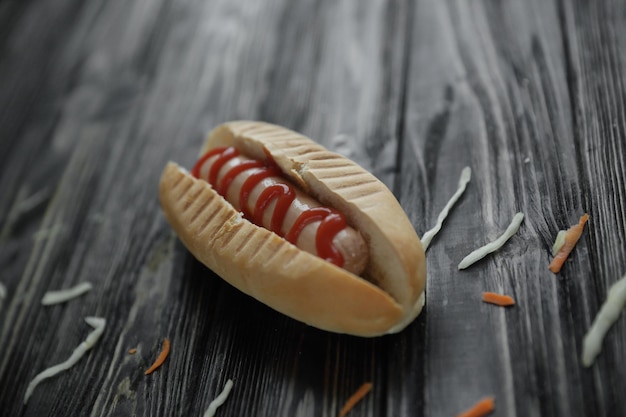 Hot-dog avec sauce sur backgroundphoto en bois avec copie espace