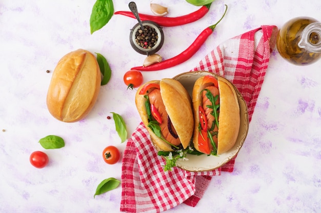 Hot dog avec des saucisses et des légumes dans le style grec. Plat poser. Vue de dessus