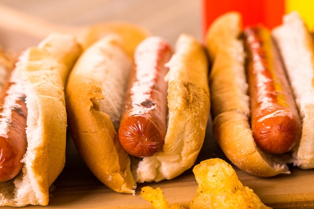 Hot-dogs grillés sur un pain à hot-dog blanc avec frites et fèves au lard sur le côté.